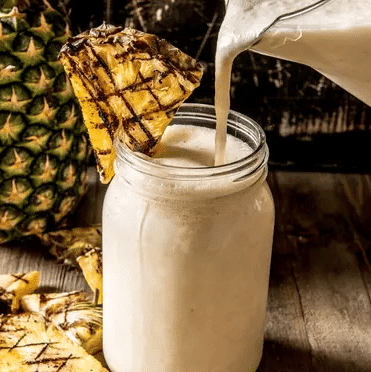 Pouring a grilled pina colada into a flass. 