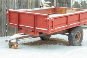 An older trailer sits unused in the snow.